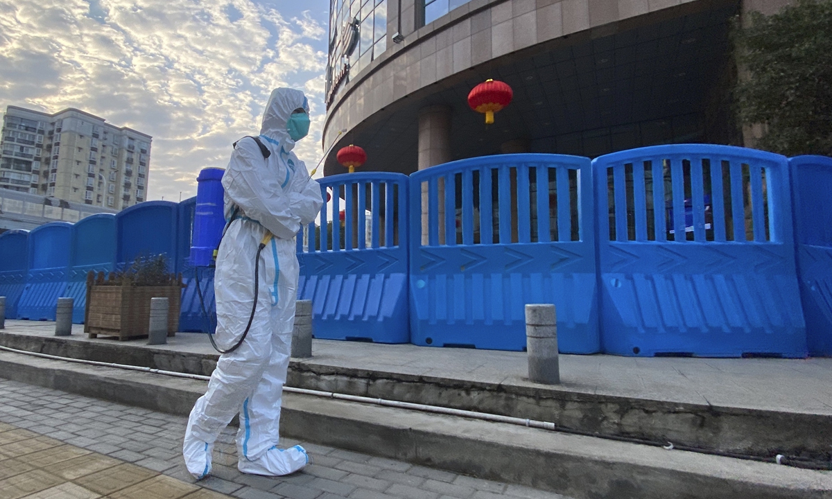A worker carrying disinfecting equipment walks outside the Wuhan Central Hospital Photo: AP